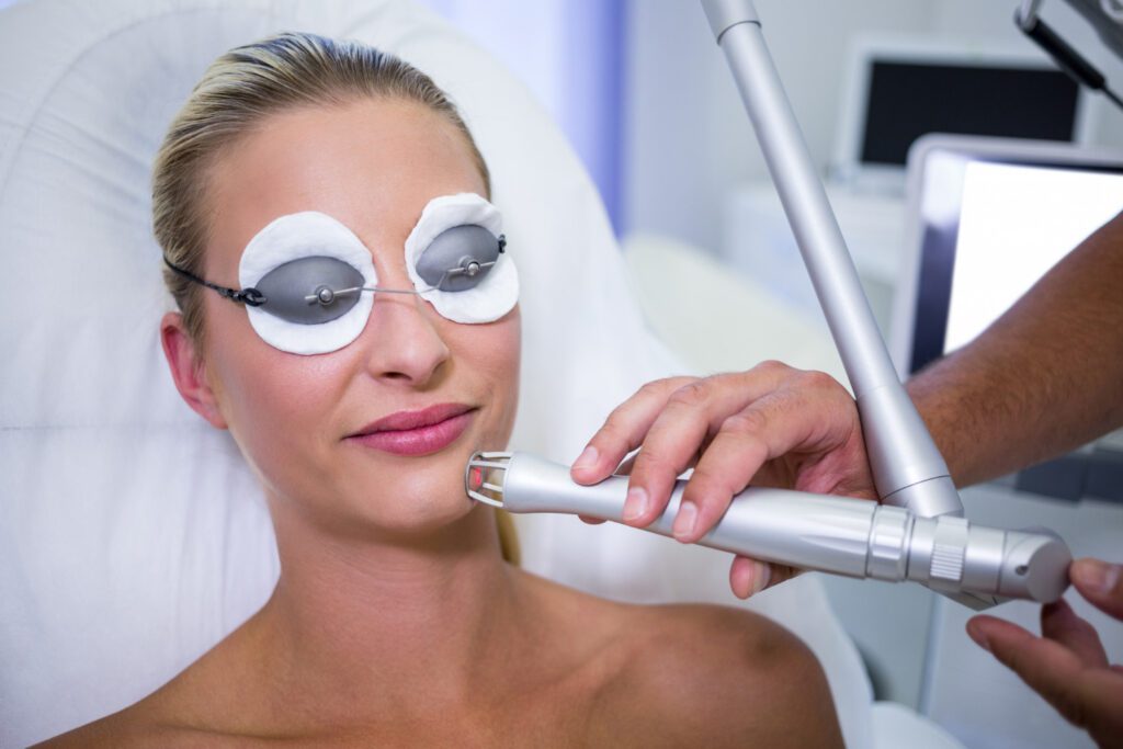 Close-up of a woman receiving professional face laser treatment by a dermatologist for scar removal.