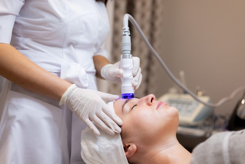 Close-up of a woman receiving professional face laser treatment by a dermatologist, focusing on the face laser treatment price and benefits for skin care