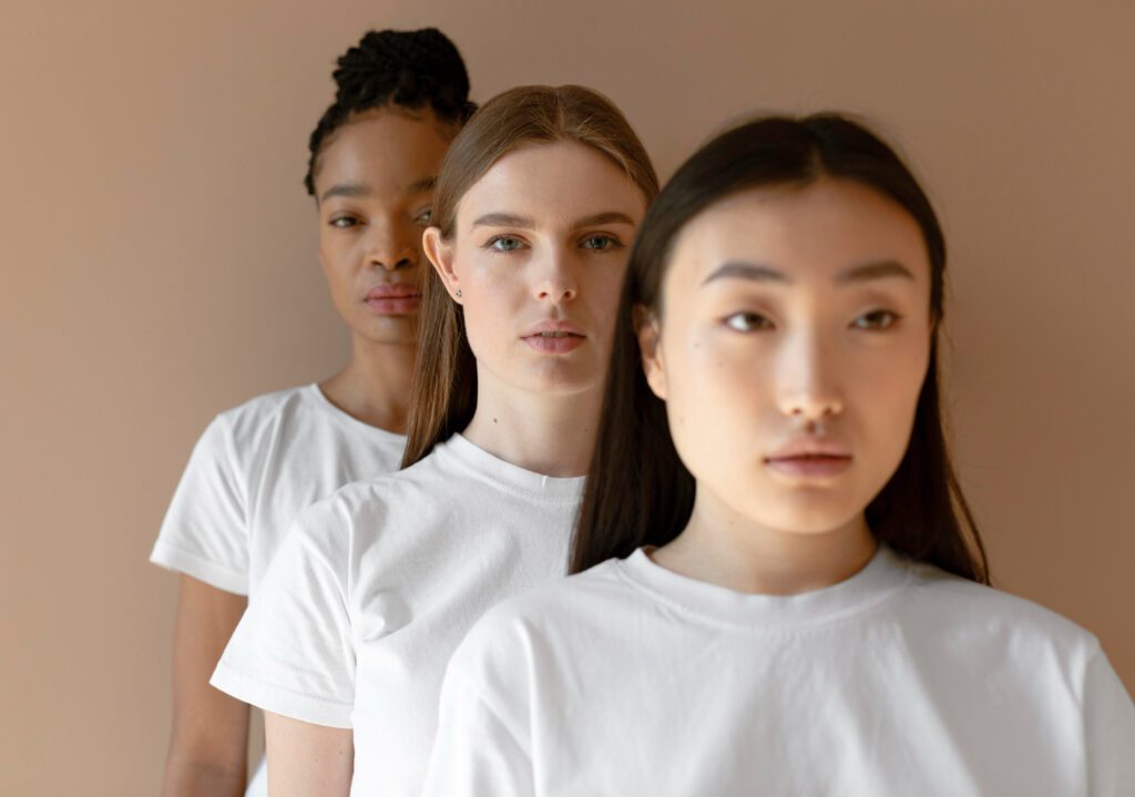 Women of different skin tones standing together in a row, showcasing diverse tan skin shades and celebrating natural beauty.